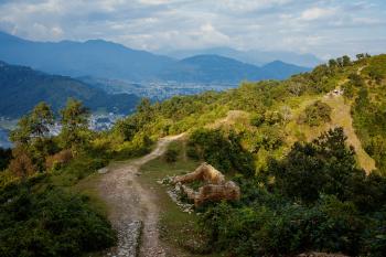 A colour photo of a path and some ruins among the greenery on a hilltop. Pokhara, Nepal, 2009.