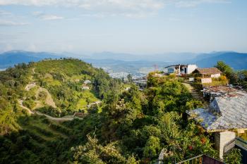 A colour photo of greenery, plantations and a small shop at a hilltop near Pokhara, Nepal, 2009.