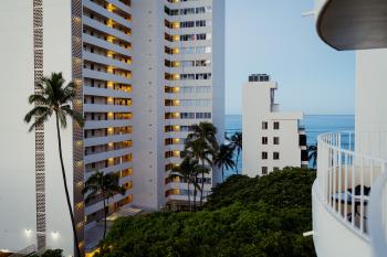 A hotel/apartment complex building in front of the Pacific ocean at sunrise