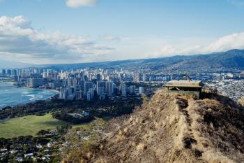 A military fortification reading "Danger, Keep off" with a panorama of Honolulu in the background