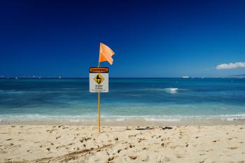 A warning sign on Waikiki beach, "Sharp coral"