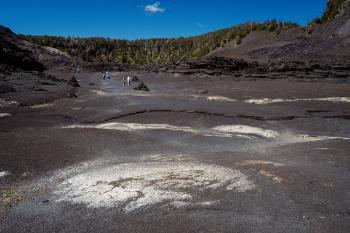 Mineral formations in the crater lake bed, with people in the background