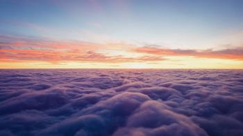 The sun is setting behind a cloud layer, photo taken from an airplane.