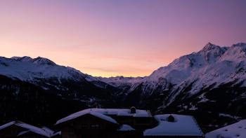 Sunrise over the mountatins, with a few lodges in the foreground
