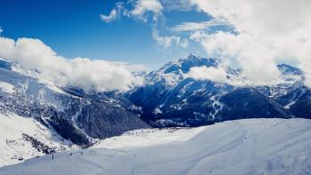 Clouds over an expansive landscape of valleys and mountains