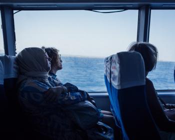 Passengers on a ferry, the sea in the background