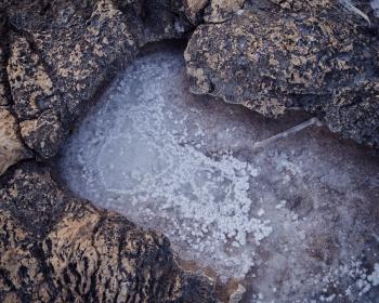 Drying salt in a rock pool, some parts of the rock in the backgound. Nice textures.